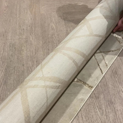 Modern gemusterter Teppich - Goldfarbene Akzentlinien auf cremefarbenem Grund